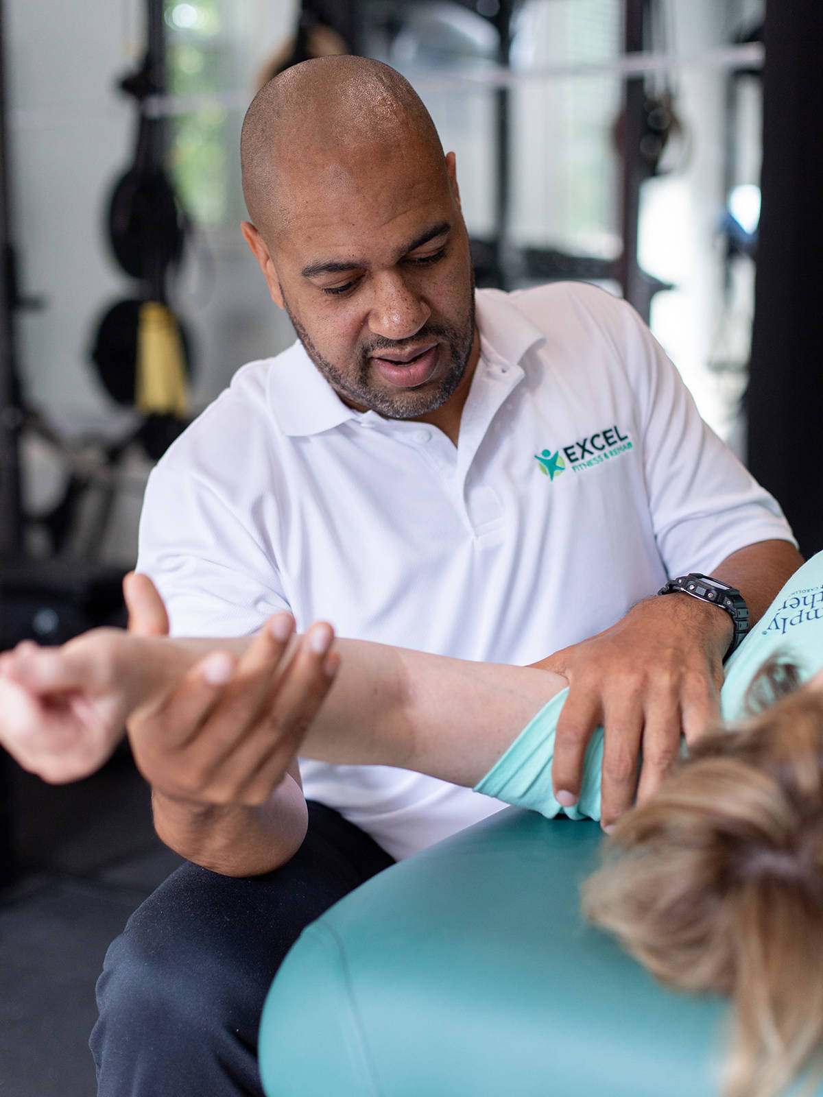 Photo of Excel Fitness and Rehab Gym - JD stretches client's arm after workout